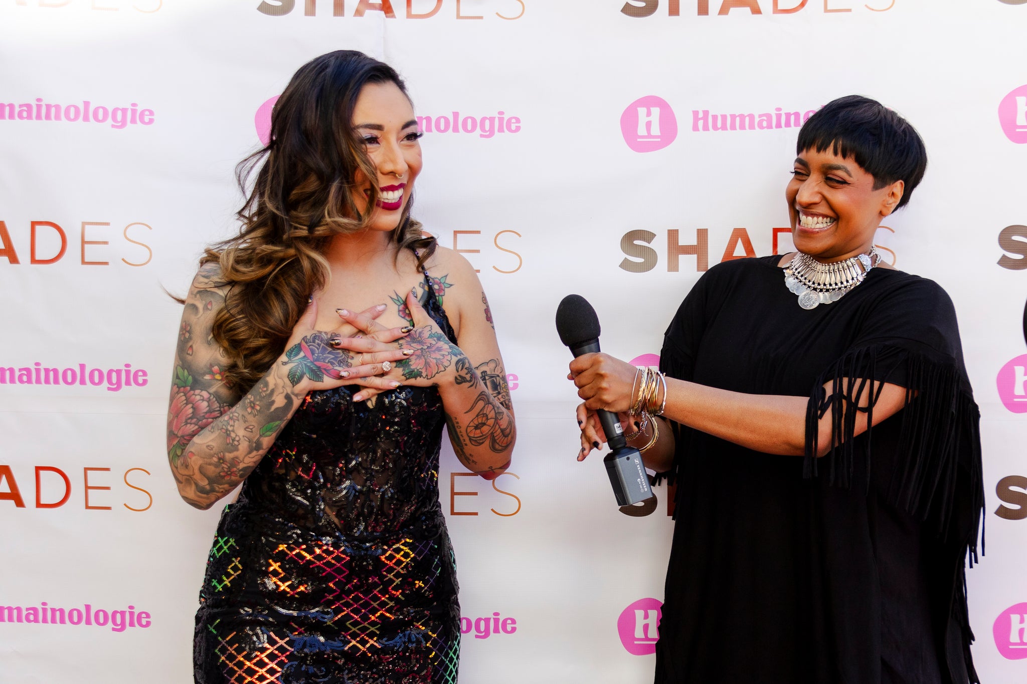 Lisa Jacobs extends microphone to Bea lisasma on the red carpet at the SHADES season two premiere.
